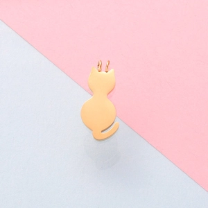 Polished gold cat-shaped metal pendant charm for DIY jewelry on colorful background