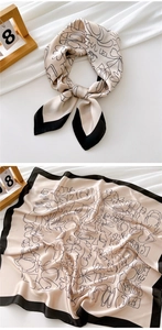 Close-up of champagne silk scarf with black floral line art and smooth satin texture