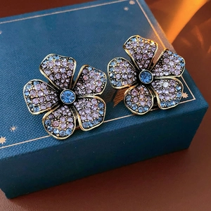 Détail de boucles d'oreilles vintage en forme de fleur avec cristaux bleus sur un coffret