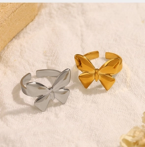Macro detail of gold and silver bow-shaped open rings with polished metallic finish