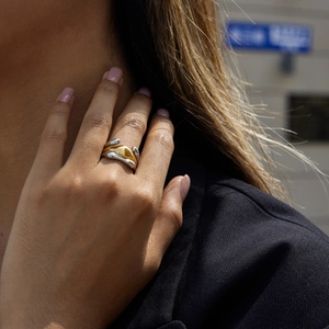 Macro shot of tiered mixed metal wavy ring showing fluid 18K gold and silver textures