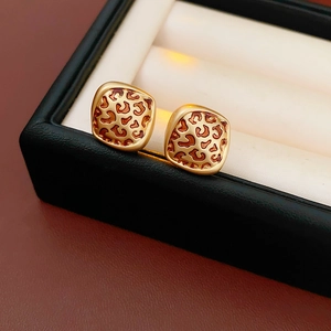Gros plan sur les boucles d'oreilles carrées dorées avec émail léopard marron