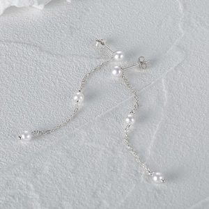 Macro view of luxury S925 sterling silver tassel chain earrings with white pearls