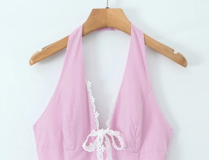 Close-up of pink striped halter dress with white lace trim and bow on wooden hanger
