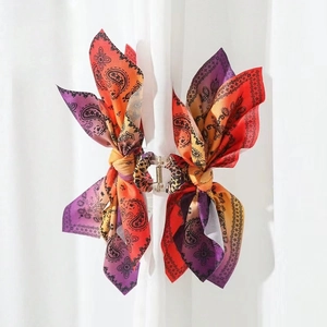 Detail of paisley and leopard print hair claw clip with purple orange silk ribbon