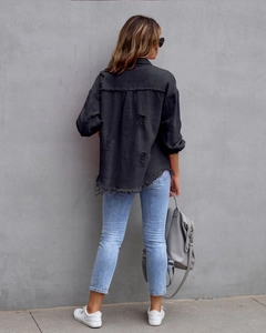 Rückansicht einer schwarzen Jeansjacke im Distressed-Look mit ausgefranstem Saum
