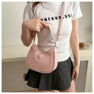 Detail of pink PU leather saddle bag with 3D heart design and adjustable shoulder strap