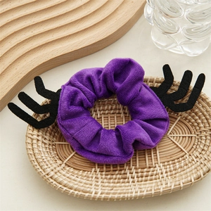 Détail d'un chouchou en peluche violette avec bois de cerf noirs en feutrine