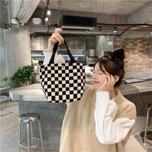 Classic checkered corduroy tote bag detail showing black handle and secure snap button
