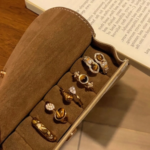 Dettaglio di cinque anelli placcati in oro con pietra occhio di tigre in scatola di velluto