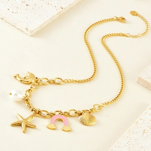 Gold ocean necklace with dolphin, pearl, starfish, and scallop pendants on chunky chain