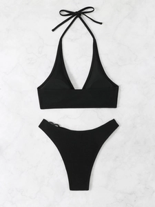 Dettaglio della trama del tessuto a coste nero del bikini a fascia con fiocco al collo
