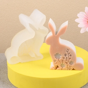 Détail macro du moule en silicone lapin 3D et bougie lapin rose à fleurs sur socle
