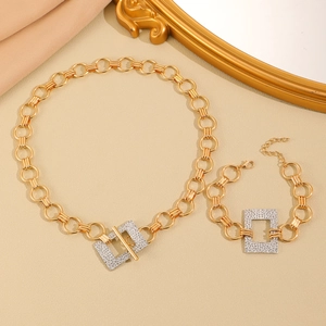 Set collana e bracciale dorati con pendente quadrato di strass su tessuto beige