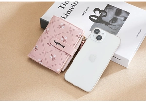 Short pink women's wallet with flower pattern and snap closure on stylish beige background