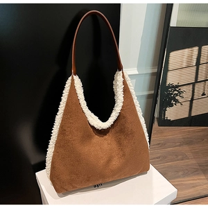 Detail of a brown suede tote bag with white faux fur trim on a white decorative box