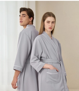 Close-up of gray waffle weave hotel robes with white piping for men and women