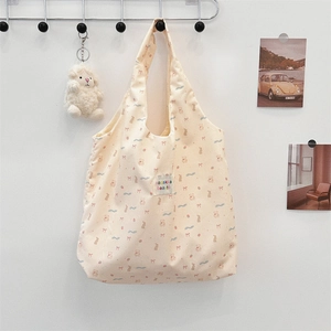 Gros plan d'un sac cabas en toile avec motifs d'animaux et écusson logo tissé détaillé