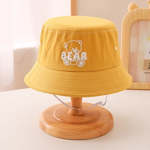 Detail of yellow cotton kids bucket hat with cute bear embroidery and white wind rope