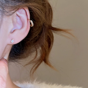 Close-up of 18K gold-plated heart stud earring and zircon ear cuff on a model's ear