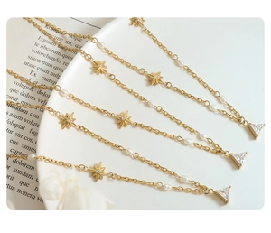 Detailed close-up of gold star pendant with pearls and triangular zircon on a chain