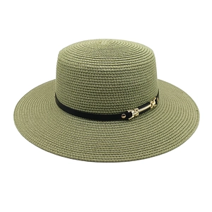 Détail d'un chapeau de paille vert sauge avec ruban en cuir noir et boucle dorée