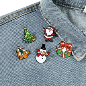 Set of 5 colorful Christmas enamel pins featuring Santa and snowman on denim jacket