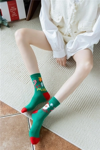 Dettaglio di calze natalizie verdi con motivi Babbo Natale e decorazioni festive