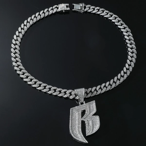 Macro shot of silver Cuban link necklace with iced-out rhinestone letter B pendant