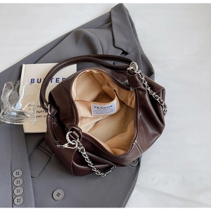 Detail of dark brown leather bag showing inner lining, pocket and chain strap
