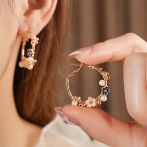 Vintage gold hoop earrings with enamel flower and pearl accents for luxury fashion