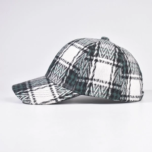 Detail of green and white plaid checkered texture on a thick wool baseball cap for winter