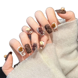 Cute chocolate theme press-on nails with 3D dessert charms and bows on white background
