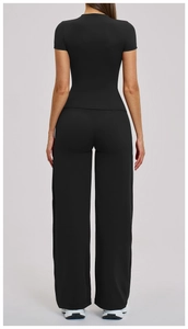 Rear view of black two-piece yoga set featuring a short sleeve top and wide leg pants