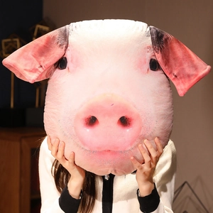 Realistic pink pig head plush pillow cushion displayed being held by a model indoors