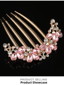 Detail of five-tooth gold hair comb with pink teardrop crystals and sparkling rhinestones