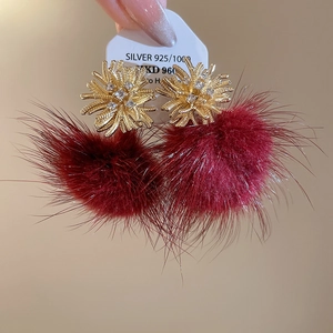 Detailed view of red faux fur ball earrings with 925 silver needle and zircon accents
