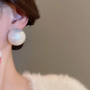 Élégant grand clou d'oreille perle ronde sur mannequin montrant un fini brillant de luxe
