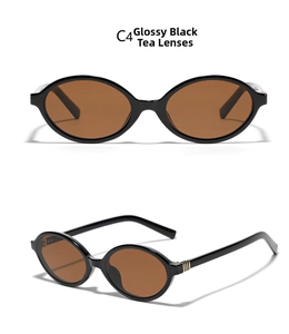 Detail view of glossy black oval glasses frames with brown lenses and golden metal accents