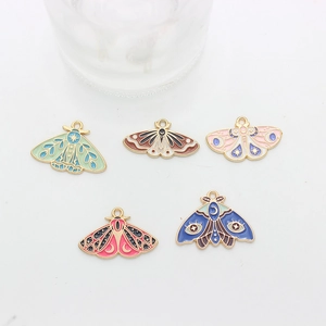 Close-up of five colorful enamel moth pendants with celestial moon and star patterns