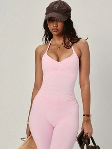 Detail eines rosa Halterneck-Sporttops und High-Waist-Shorts mit schmaler Passform und Stretch