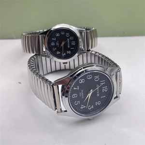 Detail view of silver elastic steel band quartz watches for couples with large digits