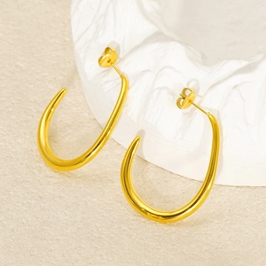 Minimalist C-shaped earrings in 18k gold plated stainless steel on a textured background