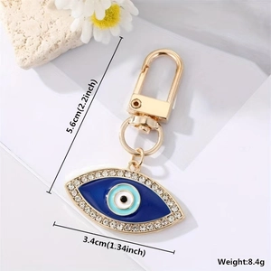 Detail of evil eye heart keychain with blue enamel and dimensions 5.6cm x 3.4cm