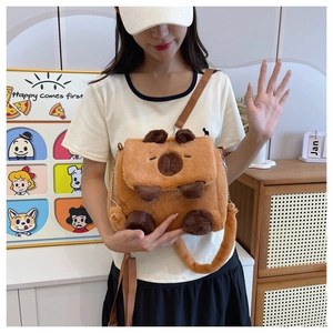 Close-up of cute plush capybara crossbody bag with soft faux fur texture on a model