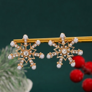 Detailed macro view of snowflake earrings with rhinestones and pearls on festive background