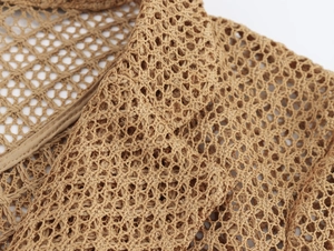 Close-up of camel crochet mesh fabric and neat hem details on a beach style outfit