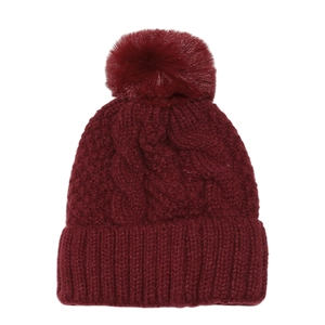 Detail of wine red cable knit beanie with large faux fur pom and ribbed cuff texture
