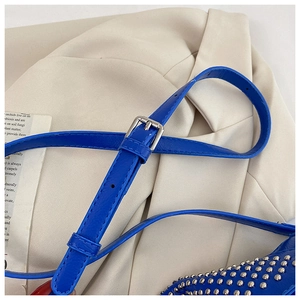Detail of electric blue leather bag with silver rivets and metal buckle strap