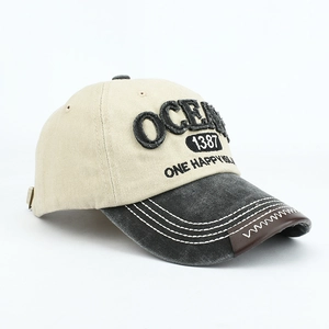 Close-up of OCEAN embroidery and leather trim detail on a vintage baseball cap